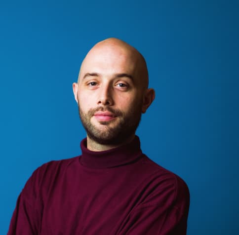 Man holding head and smiling - blue background
