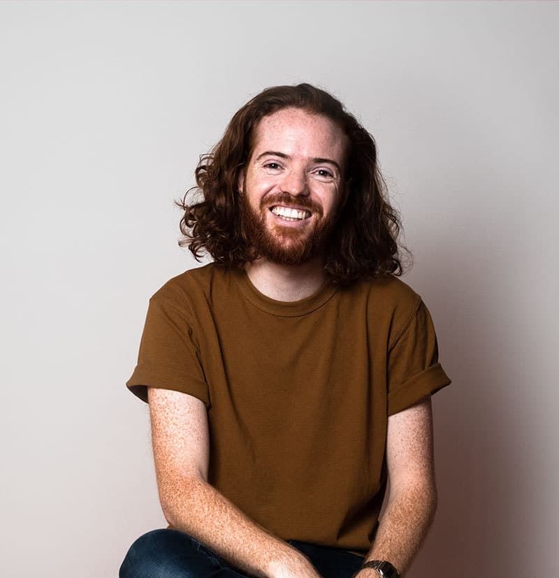 Man sitting and smiling - gray background