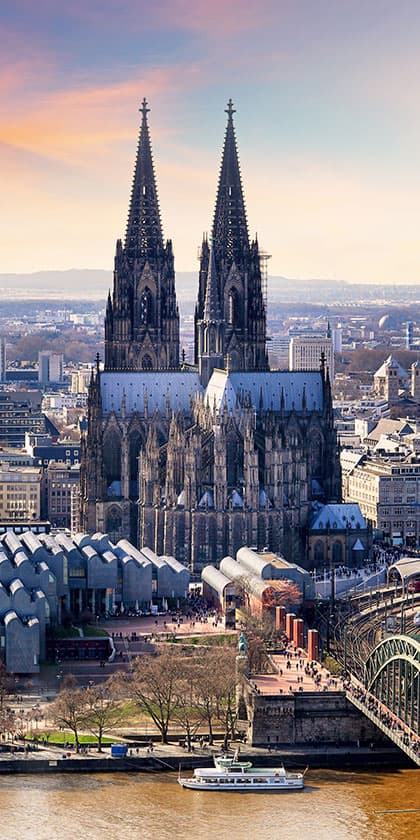 Kölner Dom am Rhein bei Sonnenuntergang.