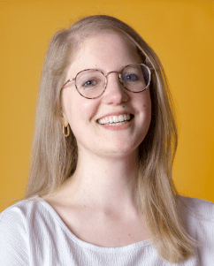 two women standing and laughing - turquoise background
