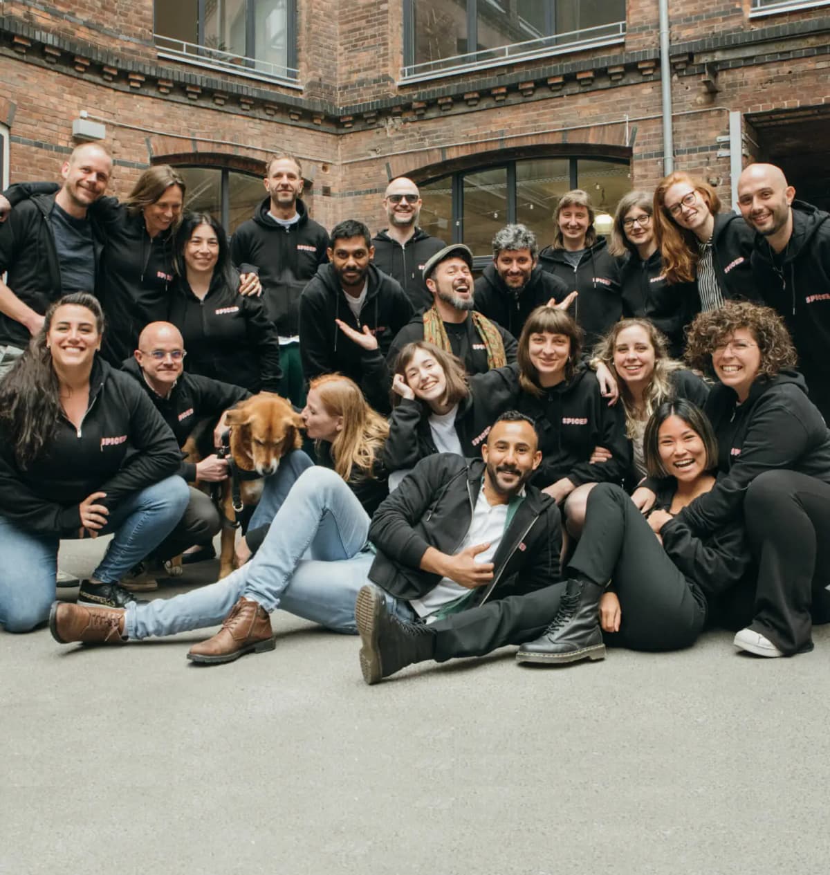 Group of people, sitting, standing, smiling - building in background