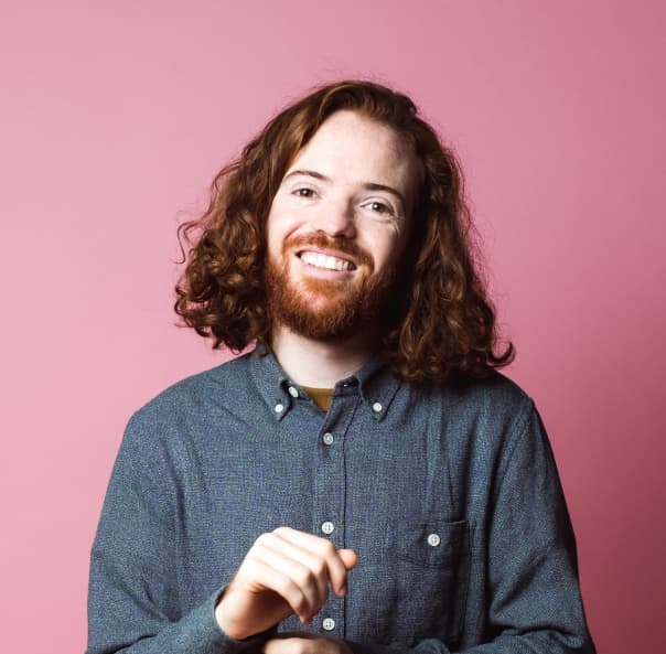 man sitting and smiling - rose background