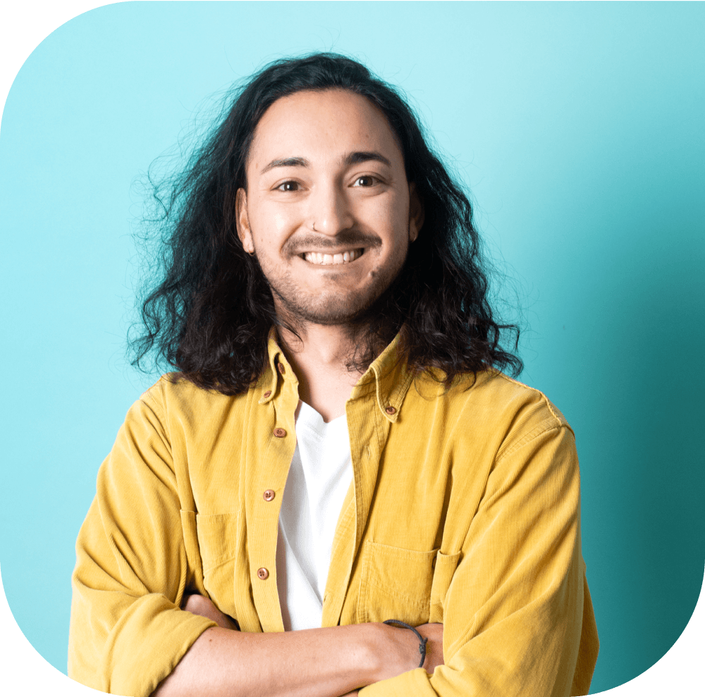 Porträt eines lächelnden Mannes mit langen Haaren vor blauem Hintergrund.